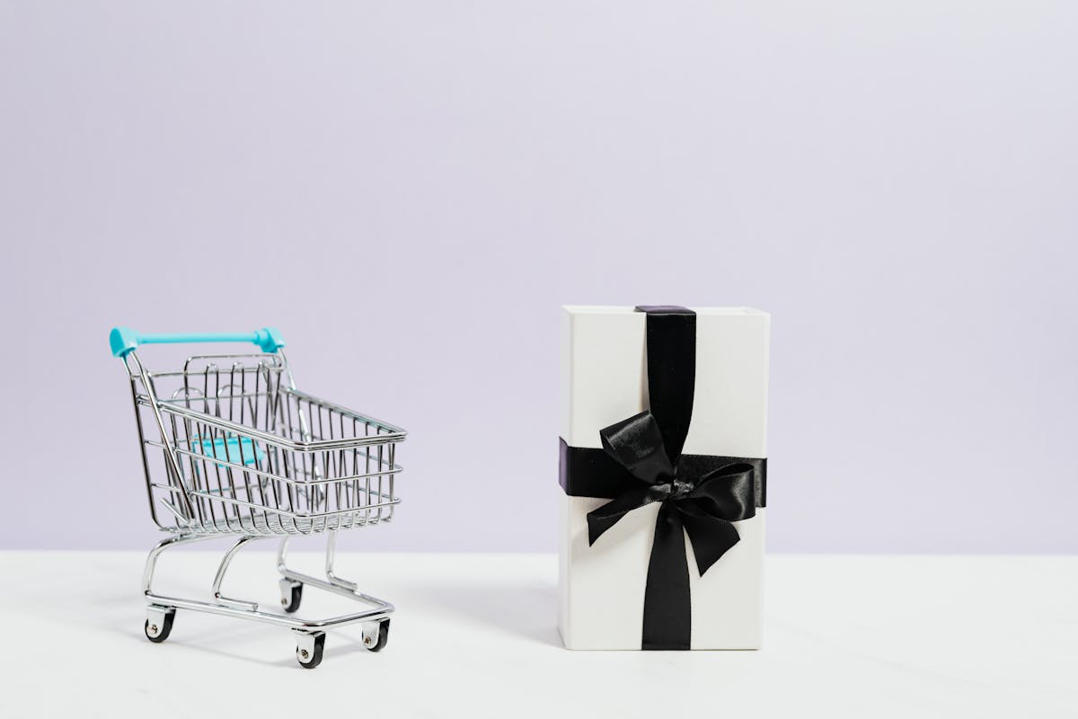 Gift box beside a small shopping cart